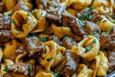 a bowl filled with pasta and beef covered in sauce