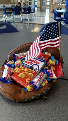 a baseball mitt filled with snacks and an american flag sitting on top of it