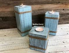 two blue candles sitting on top of each other in front of a wooden wall and floor