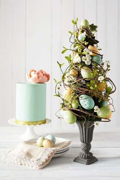 an easter tree next to a cake on a plate