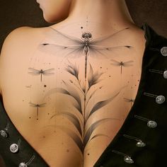 the back of a woman's body with dragonflies on it