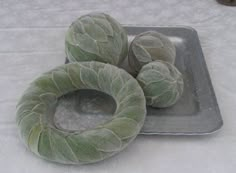 three cabbage buns sitting on top of a metal pan covered in ice and snow