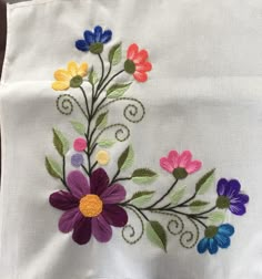 an embroidered piece of cloth with flowers on it