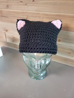 Black Cat Beanie with Pink Ears Hat for Kids and Adults This warm and soft cat beanie will keep you and your kid's head warm this winter.  The cat beanie is black with soft pink ears.  The kitty beanie is knit with soft acrylic yarn.  You can customize the colors of this beanie.  Just message me with the colors you're looking for. This cat beanie fits kids and adults.   This item is made special for you. If concerned about time, please inquire about my current back log or select priority mail at checkout and your order will be moved to the top of my queue.  With over 40 years of knitting and crochet experience, my products are high quality, well made and professionally finished. Check out my store for other fun custom hats.  All items can be customized for you.  I create them personally in Adjustable Black Hat With Ears, Black One Size Cat Ears Hat, Winter Adjustable Cat Ears Beanie, Adjustable Cat Ears Beanie For Winter, Adjustable Winter Beanie With Cat Ears, Winter Beanie With Adjustable Fit And Cat Ears, Cute Black Mini Hats One Size, Black Cat Ears Hat With Cat Design, Black Cat Design Hat With Cat Ears