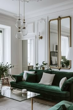 a living room filled with green couches and mirrors