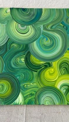 an abstract painting with green and blue swirls on the canvas, ready to be painted