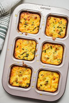 a muffin tin filled with four different types of breakfast casseroles on top of a white counter