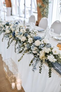 the table is set with white and blue flowers