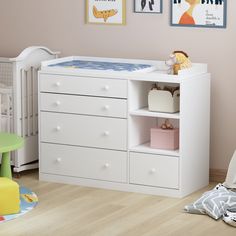 a baby's room with white furniture and pictures on the wall