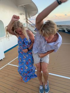 a man and woman are dancing on the deck of a cruise ship