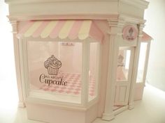 a pink cupcake shop is on display