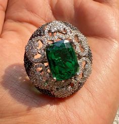 Emerald India Ring featuring semi precious green stone and cz diamonds. Ideal to pair with your india western sarees and formal outfits. These large statement cocktail diamond ring will elevate your look. Perfect gift for her and gift for sister. *𝐏𝐑𝐎𝐃𝐔𝐂𝐓 𝐃𝐄𝐓𝐀𝐈𝐋* * 𝐌𝐚𝐭𝐞𝐫𝐢𝐚𝐥: Brass * 𝐏𝐥𝐚𝐭𝐢𝐧𝐠: White Rhodium Plated * 𝐒𝐭𝐨𝐧𝐞: AAA-quality CZ Diamond. *𝐃𝐈𝐌𝐄𝐍𝐒𝐈𝐎𝐍𝐒* * Length 3.4 cm, Width 3 cm, Height 1.3 cm, Weight 10 gm Each. * Adjustable 𝐕𝐢𝐬𝐢𝐭 𝐎𝐮𝐫 𝐅? Elegant Large Stone Green Emerald Ring, Luxury Large Stone Green Emerald Ring, Western Sarees, Luxury Dazzling Green Emerald Ring, Luxury Green Emerald Statement Ring, Luxury Faceted Emerald Rings, Cocktail Diamond Ring, Ladies Rings, Ring Luxury