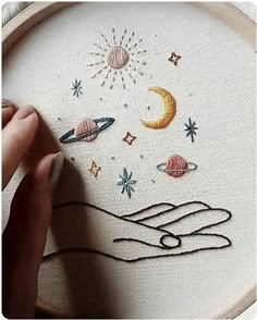 someone is working on an embroidery project with the moon and stars in the sky above them