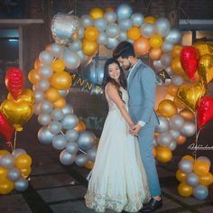 a newly married couple standing in front of balloons