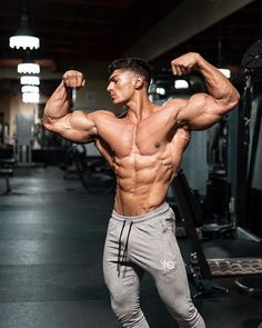 a man flexing his muscles in the gym