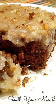 two pieces of cake sitting on top of a white plate with frosting and nuts