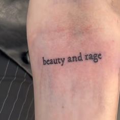 a person with a tattoo saying beauty and rage