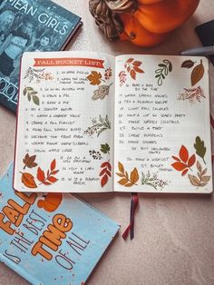 an open book sitting on top of a table next to a pumpkin and other items