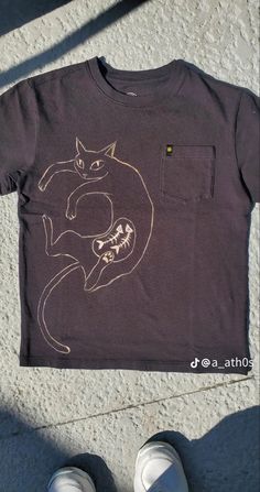 a person standing next to a t - shirt with a cat on it's chest