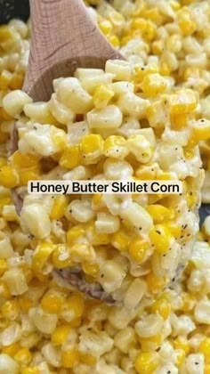 a wooden spoon is scooping corn from a skillet