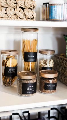 the shelves are filled with various types of spices and other things in glass jars on them