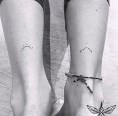 two people with matching tattoos on their feet, one is holding the other's hand