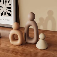 three ceramic figurines sitting on top of a wooden table next to a framed photo