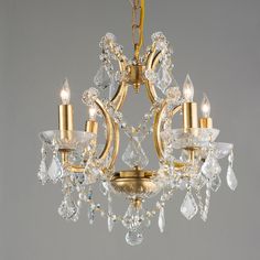 a gold chandelier with crystal drops hanging from it