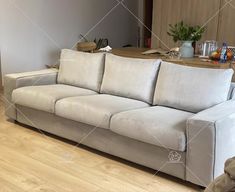 a white couch sitting on top of a hard wood floor