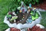 there is a miniature garden in the shape of a bird bath