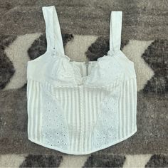 With Jean Layla Bustier Eyelet Top Size Small. Zips In Back. 100% Cotton. I Bought On Depop Brand New And Never Wore It. Seller Removed Tags. Unfortunately I Couldn’t Fill The Bust. White Cropped Top With Boned Bodice, White Cropped Crop Top With Removable Bra Pads, Feminine Fitted Cami Crop Top, Fitted Feminine Cami Crop Top, Chic Cropped Cotton Corset, Fitted White Crop Top With Boned Bodice, Elegant Fitted Cotton Crop Top, Chic Summer Corset With Hook And Eye Closure, Elegant Cropped Summer Corset