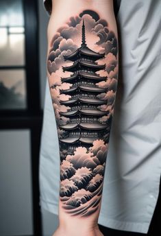 a person with a tattoo on their arm that has clouds and pagodas in the sky