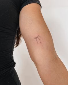 a woman's arm with a small tattoo on the left side of her arm