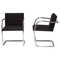 a pair of black chairs sitting next to each other