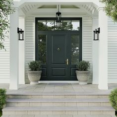 a front door with two planters on the steps