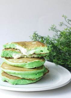 a stack of green pancakes on a white plate