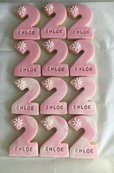 pink cookies with numbers and flowers on them are arranged in the shape of numerals