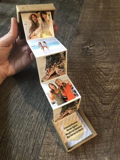 a person holding up a box with pictures on it that is open to show the inside