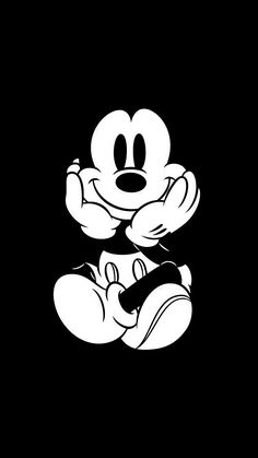 the mickey mouse logo in black and white on a dark background, it looks like he is