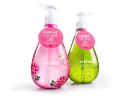 two bottles of hand soap sitting next to each other on a pink tile background with flowers