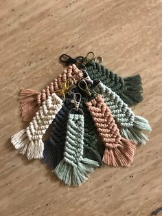 six key chains with tassels on top of a wooden table