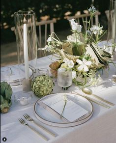 the table is set with flowers and candles