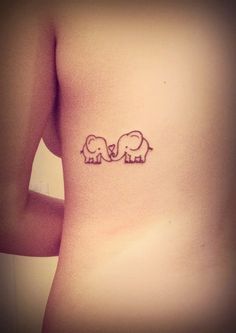 an elephant tattoo on the back of a woman's stomach