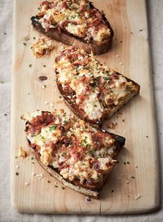 three slices of pizza sitting on top of a wooden cutting board