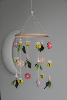 a mobile with flowers and bees hanging from it