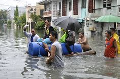 some people are riding on rafts in the water with an umbrella over their heads