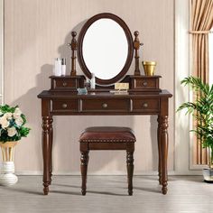 a dressing table with a mirror and stool in a room next to a potted plant