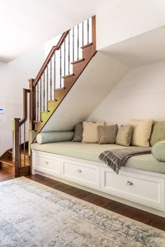 a white couch sitting under a stair case