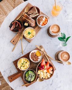 three bowls of food on a table with chopsticks and drinks next to them