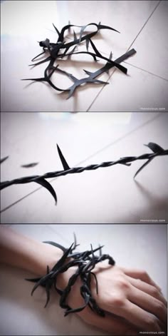 barbed wire is being held by someone's hand with their hands on the ground